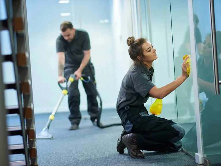 Nettoyage de bureaux en entreprise : lavage d'une cloison vitrée à la microfibre et shampouinage de la moquette du couloir