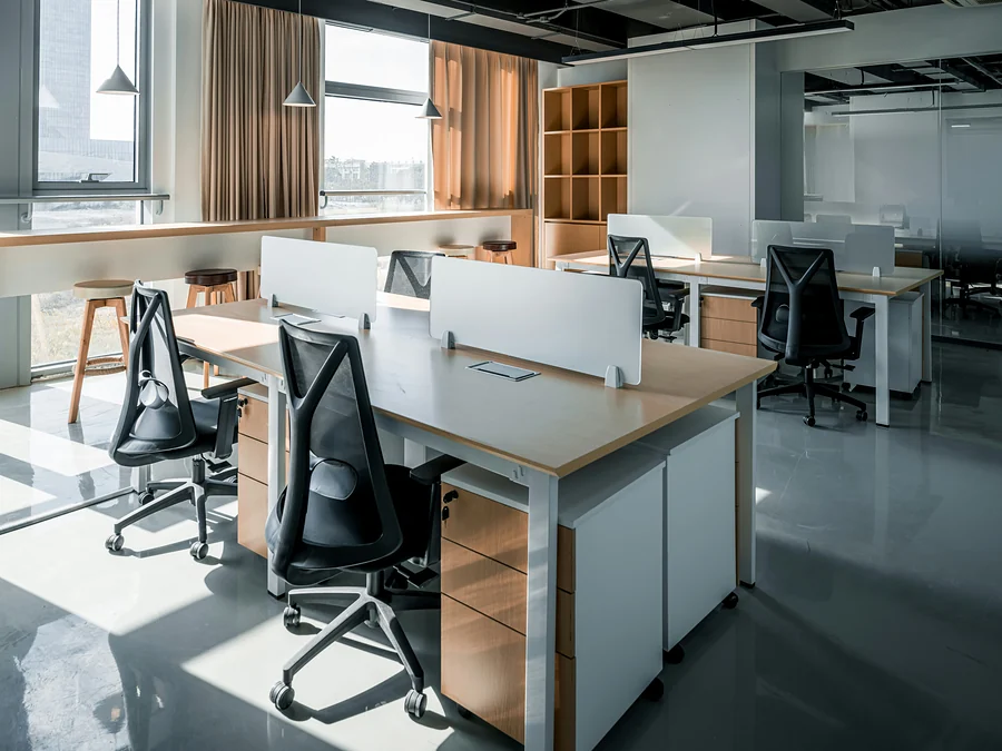Nettoyage de bureaux à Bruxelles : open space moderne et impeccable, bureaux en bois et fauteuils noirs