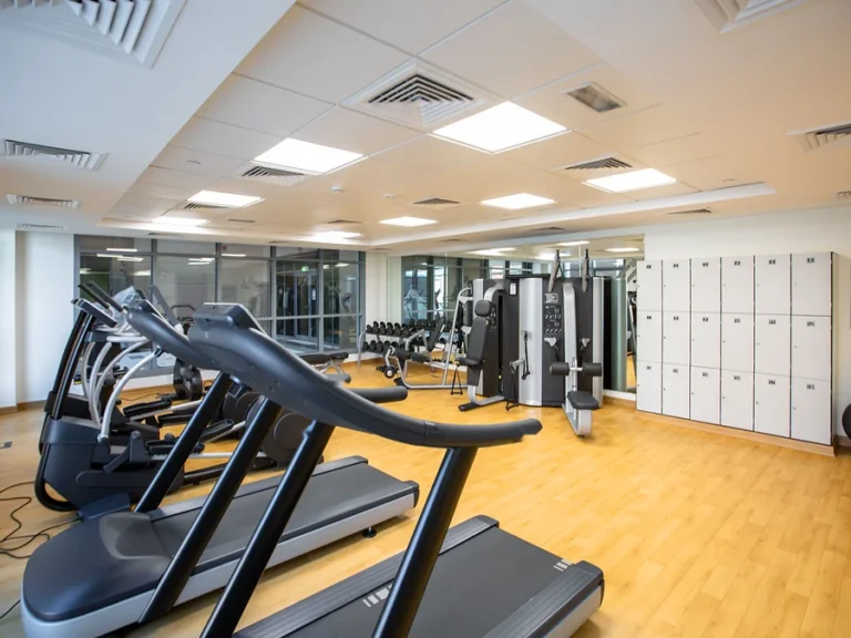 Nettoyage de salle de sport à Bruxelles : plateau fitness, tapis de course et casiers blancs impeccables